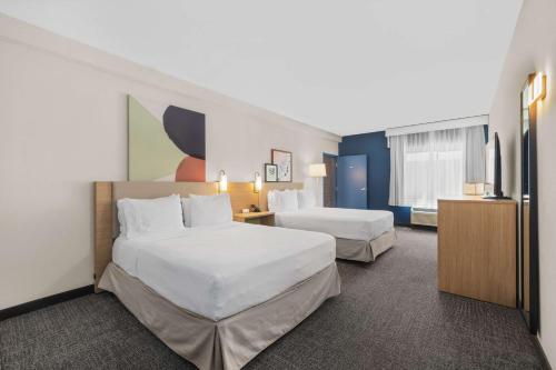 a hotel room with two beds and a tv at Spark by Hilton Bakersfield Central in Bakersfield