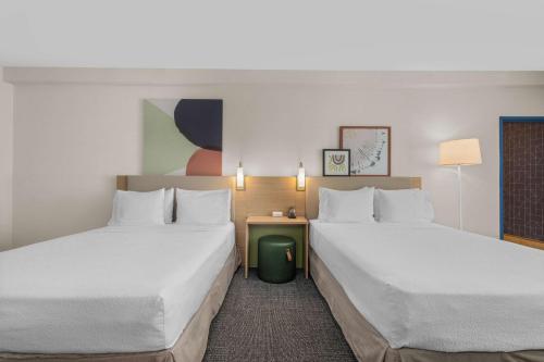 a hotel room with two beds and a table at Spark by Hilton Bakersfield Central in Bakersfield