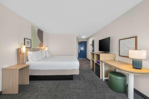 a hotel room with a bed and a desk at Spark by Hilton Bakersfield Central in Bakersfield