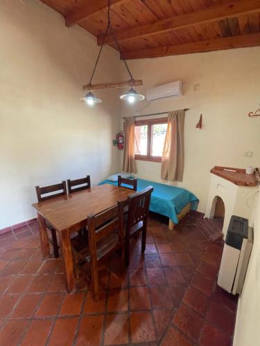 a dining room with a table and a bed at Cabañas Terrazas del Sol in Villa Carlos Paz