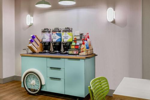 a cart in a room with a table and chairs at Spark by Hilton Denver International Airport in Denver