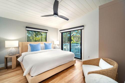 a bedroom with a large bed and a chair at Pines & Palms Resort in Islamorada