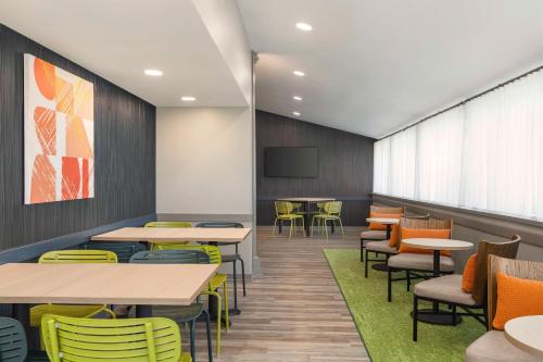 a waiting room with tables and chairs and a tv at Spark By Hilton Mystic Groton in Mystic