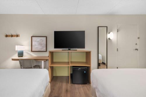 a hotel room with two beds and a desk with a tv at Spark by Hilton Colorado Springs I 25 Central in Colorado Springs