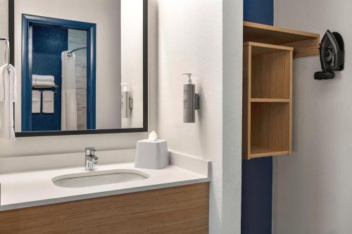 a bathroom with a sink and a mirror at Spark By Hilton Mystic Groton in Mystic