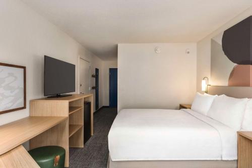 a hotel room with a bed and a flat screen tv at Spark By Hilton Mystic Groton in Mystic