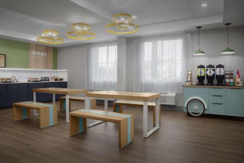 a kitchen with two tables and benches in a room at Spark by Hilton Miami Doral in Miami