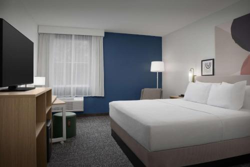 a hotel room with a bed and a television at Spark by Hilton Miami Doral in Miami