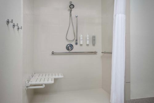 a white bathroom with a shower with a shower curtain at Spark by Hilton Miami Doral in Miami