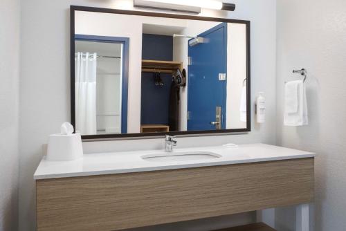 a bathroom with a sink and a large mirror at Spark by Hilton Miami Doral in Miami