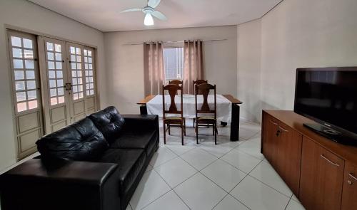 a living room with a couch and a table and a television at SOBRADO - 5 quartos - 4 banheiros - 4 vagas de garagem in Campo Grande