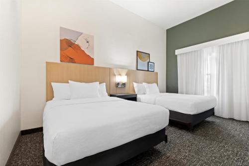 a hotel room with two beds and a window at Spark by Hilton Panama City Beach in Panama City Beach