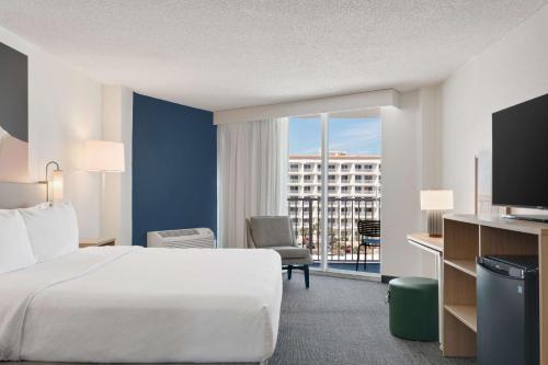オーモンド・ビーチにあるSpark by Hilton Ormond Beach Oceanfrontのベッドと大きな窓があるホテルの部屋
