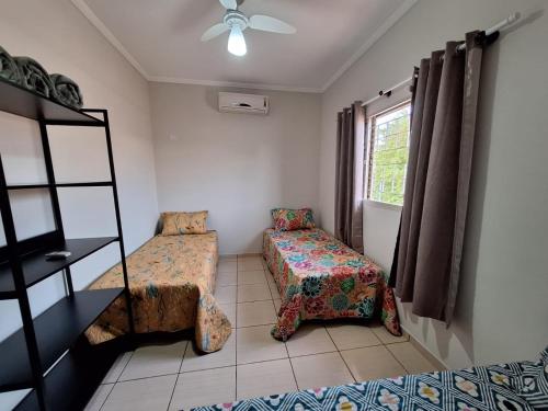 a bedroom with a bed and a chair and a window at SOBRADO - 5 quartos - 4 banheiros - 4 vagas de garagem in Campo Grande