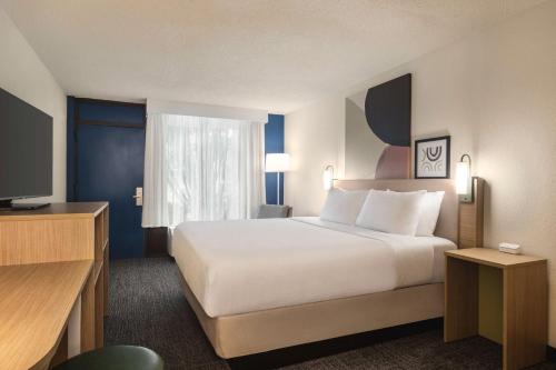a hotel room with a large bed and a television at Spark by Hilton Sarasota Siesta Key Gateway in Sarasota