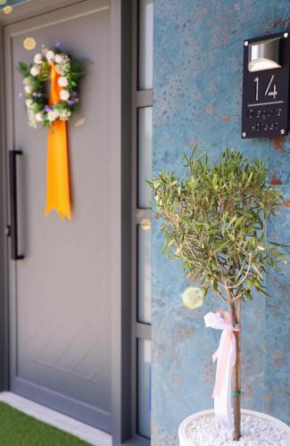 a door with a plant and a clock next to it at Apartment Simply 205 in Gázion