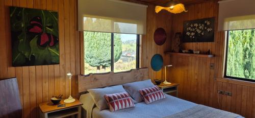 a bedroom with a bed with two pillows on it at Hostal Boutique El Vergel Azul in Castro