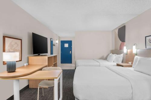 a hotel room with two beds and a desk at Spark By Hilton St. Augustine Historic District in Saint Augustine