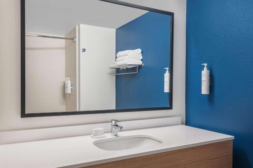 a bathroom with a sink and a large mirror at Spark By Hilton St. Augustine Historic District in Saint Augustine