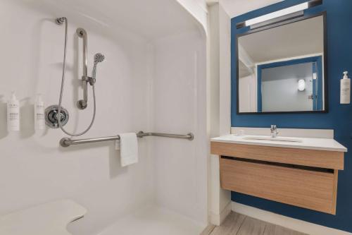 a bathroom with a sink and a shower with a mirror at Spark By Hilton St. Augustine Historic District in Saint Augustine