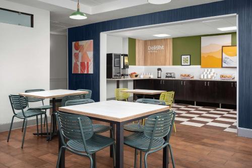 a dining room with tables and chairs and a kitchen at Spark by Hilton Tampa Brandon in Tampa