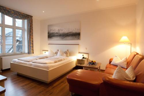a bedroom with a large bed and a couch at Hotel Restaurant Friedrichs in Nebel