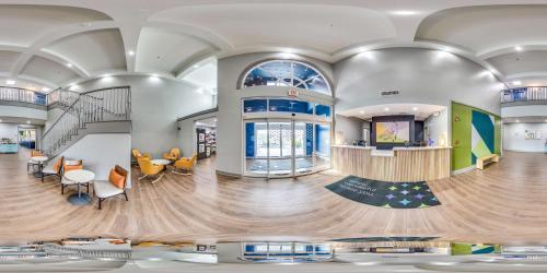 a lobby of a building with a staircase and a lobby at Spark by Hilton Commerce, GA in Commerce