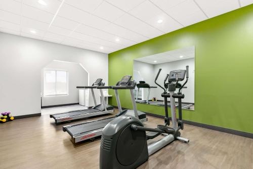 a gym with tread machines and a green wall at Spark by Hilton Commerce, GA in Commerce
