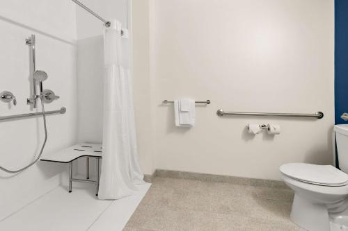 a white bathroom with a toilet and a shower at Spark by Hilton Commerce, GA in Commerce