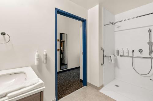 a bathroom with a sink and a shower and a mirror at Spark by Hilton Commerce, GA in Commerce
