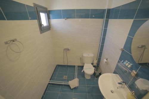 a bathroom with a toilet and a sink and a mirror at Eco Paralia in Paralia Katerinis