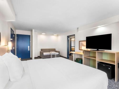 a hotel room with a large bed and a flat screen tv at Spark by Hilton Augusta in Augusta
