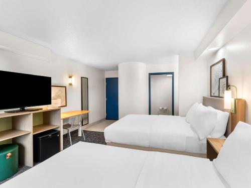 a hotel room with two beds and a flat screen tv at Spark by Hilton Augusta in Augusta