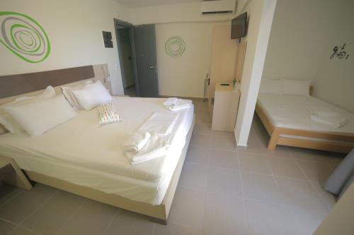 a bedroom with a large white bed and a mirror at Eco Paralia in Paralia Katerinis