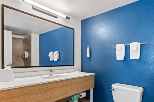 a bathroom with a sink and a mirror and a toilet at Spark by Hilton Port Wentworth Savannah in Port Wentworth