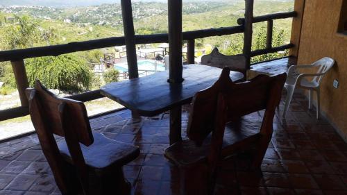 a table and chairs on a porch with a view at Cabañas Terrazas del Sol in Villa Carlos Paz