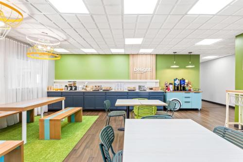a cafeteria with tables and chairs and a counter at Spark By Hilton Oak Forest I-57 in Oak Forest