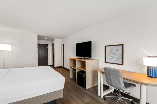 a hotel room with a bed and a desk with a computer at Spark By Hilton Oak Forest I-57 in Oak Forest