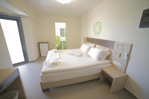 a bedroom with a bed with white sheets and pillows at Eco Paralia in Paralia Katerinis