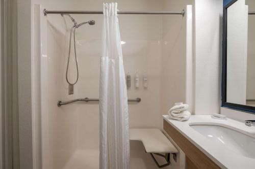 a white bathroom with a shower and a sink at Spark by Hilton Savannah Airport in Savannah