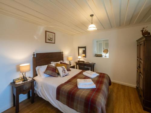 ein Schlafzimmer mit einem Bett mit zwei Handtüchern darauf in der Unterkunft Caminho Gerês - Heritage Eco-Cottage - jacuzzi in Lindoso