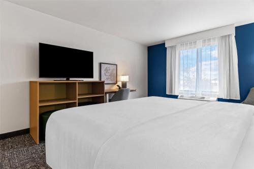 a hotel room with a large bed and a flat screen tv at Spark By Hilton Merrillville in Merrillville
