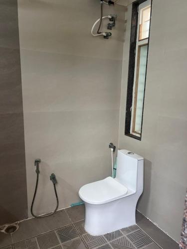 a bathroom with a toilet and a mirror on the wall at Skandasiri Hampi homestay in Sandūr