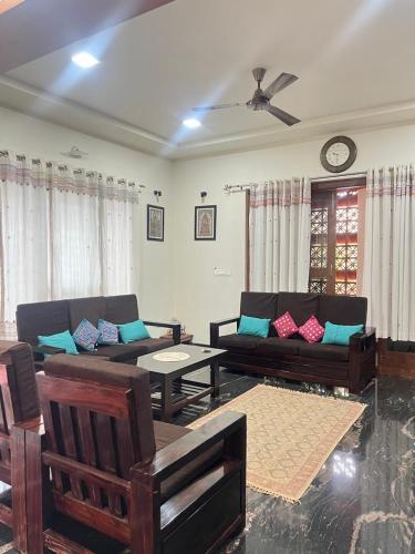 a living room with two couches and a table at Skandasiri Hampi homestay in Sandūr
