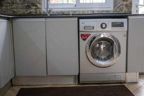 a washer and dryer in a kitchen under a counter at Villa 3 niveau avec jacuzzi, terrasse et cour in Birkhadem