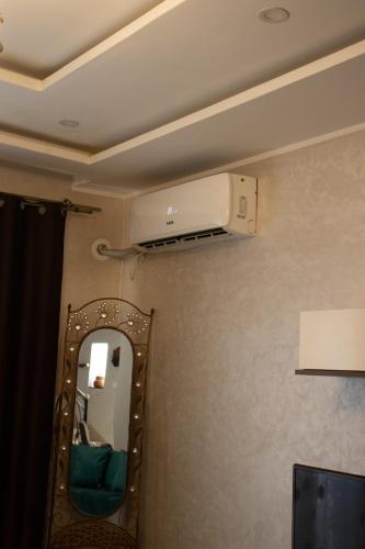 a room with a mirror and a air conditioner at Villa 3 niveau avec jacuzzi, terrasse et cour in Birkhadem