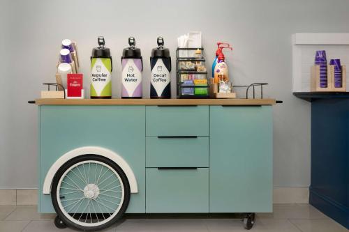 a blue cart with bottles on top of it at Spark By Hilton Evansville East, In in Evansville