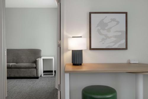 a living room with a lamp and a couch at Spark By Hilton Evansville East, In in Evansville