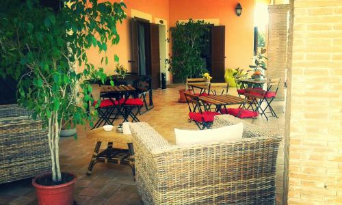 a patio with tables and chairs and a table with a tree at Villa Elegance in Ladispoli
