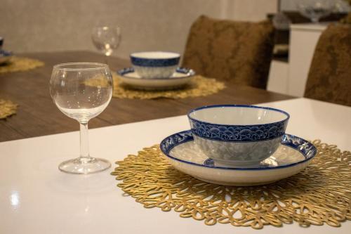 a table with a bowl and a glass of wine at Villa 3 niveau avec jacuzzi, terrasse et cour in Birkhadem